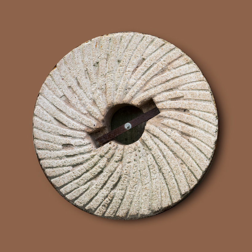Image contexte Ar Milin Coz, meule de pierre en silex sur fond brun