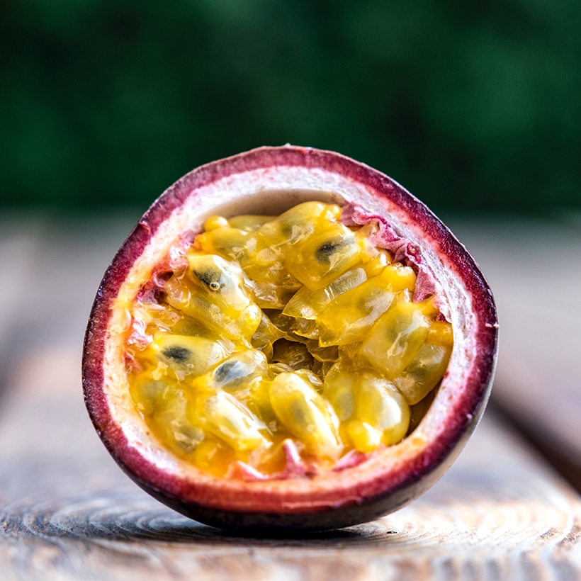 Image contexte Tropic Kiss, fruit de la passion ouvert, posé sur une planche en bois
