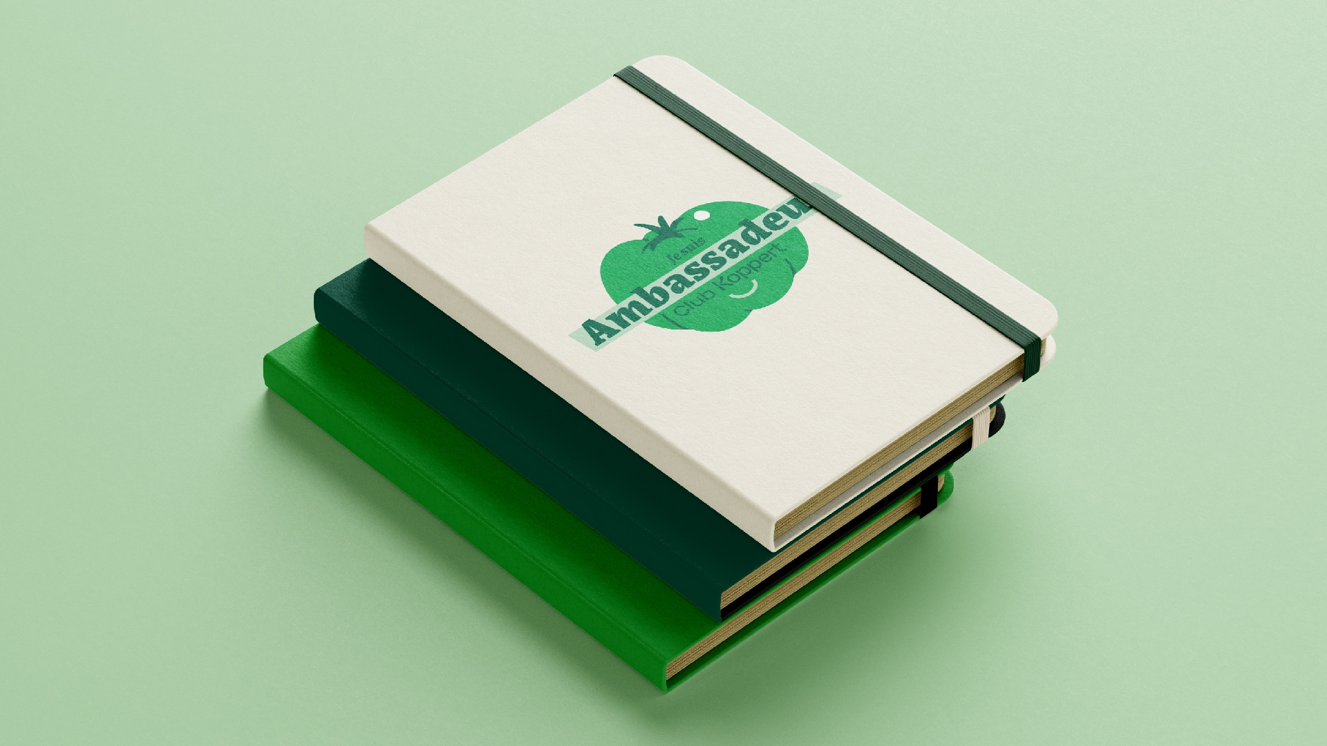 Une pile de carnets personnalisés avec le logo ”Je suis ambassadeur Koppert” sur une illustration de tomate